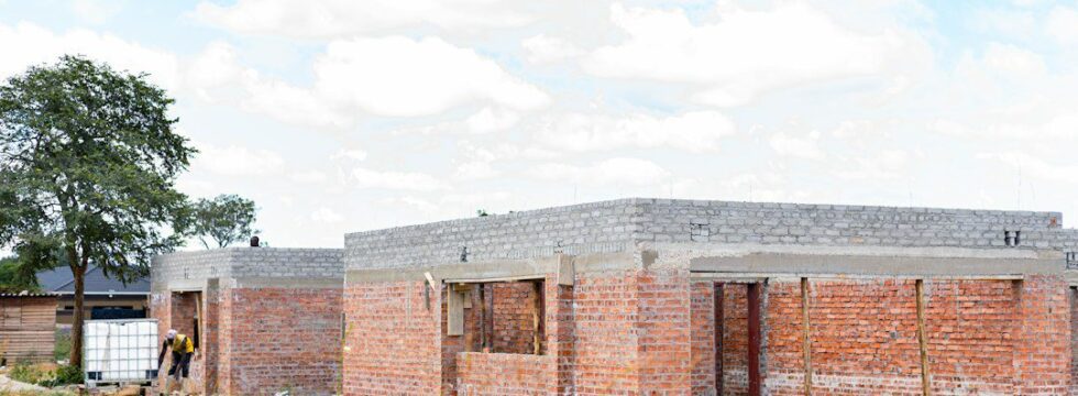 Development finance cost overrun UK - half-built house construction site